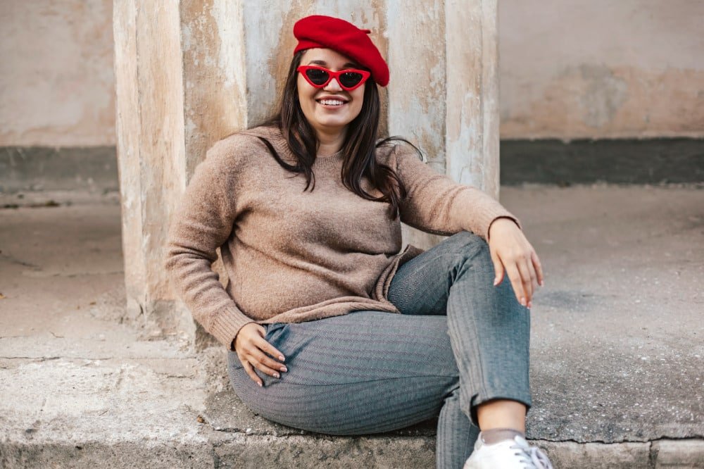 smiling plus-size woman leaning against pole