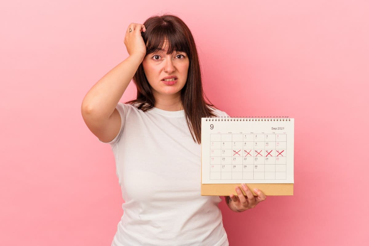 woman holding crossed out calendar worried