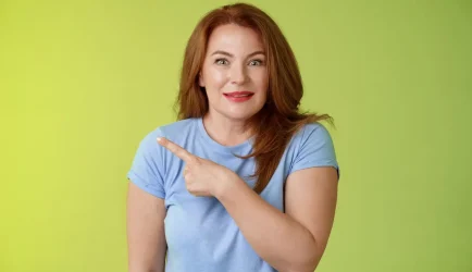 surprised-excited-middleaged-wondered-redhead-woman-pointing-left-amused-standing-thrilled-joyful-green-wall-look-camera-curious-interested_1258-46305-1.jpg